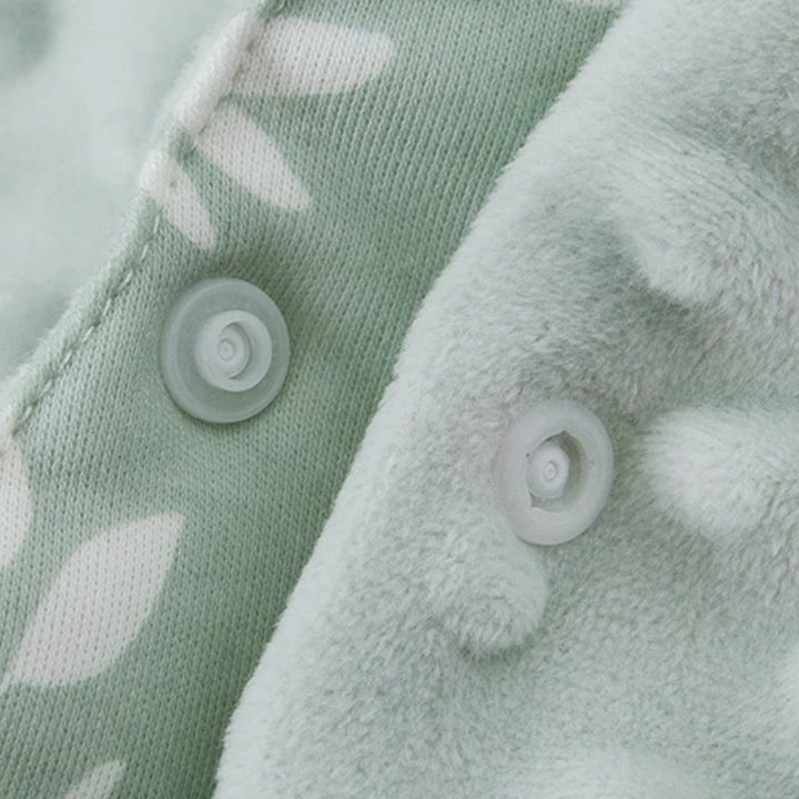 Close-up of secure plastic press studs and snap button closures on a soft minky baby travel blanket.