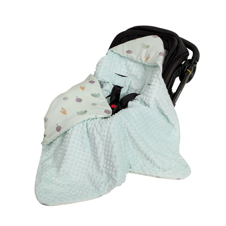Green veggie print hooded baby wrap blanket inside a black pram capsule with minky dot lining fabric details.