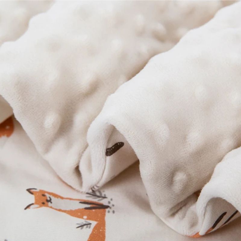 Soft cotton blend outer shell and plush sensory minky dot inner lining of an Australian universal pram wrap.