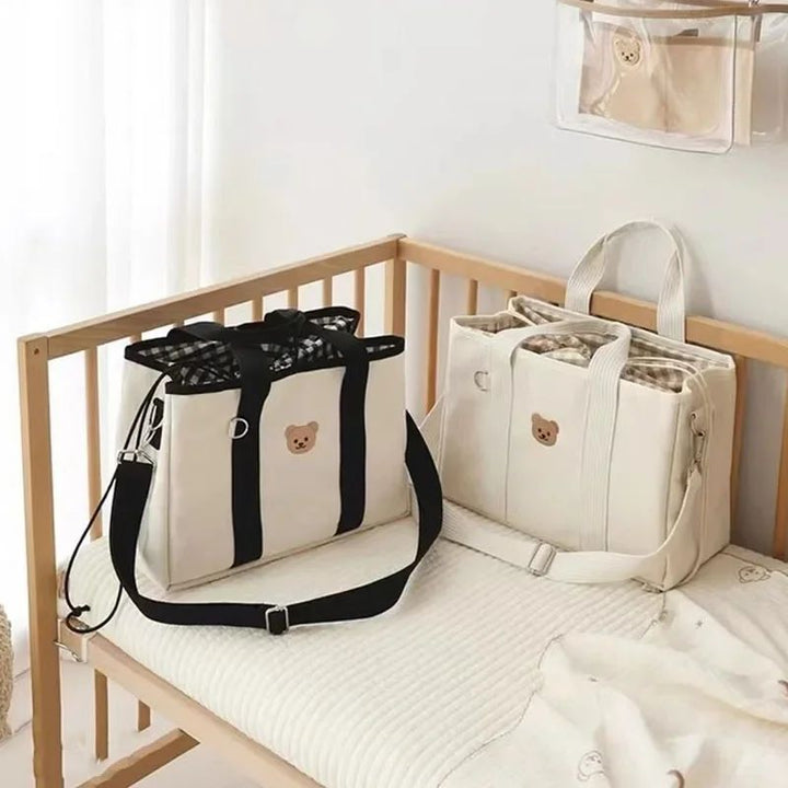 Aion baby bag tote showing dual top handles and detachable adjustable shoulder strap