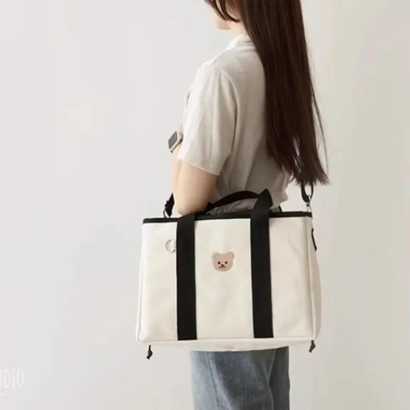 Aion nappy bag handbag in black with bear motif appliqué, front view