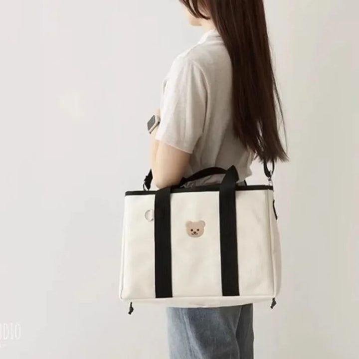 Aion nappy bag handbag in black with bear motif appliqué, front view