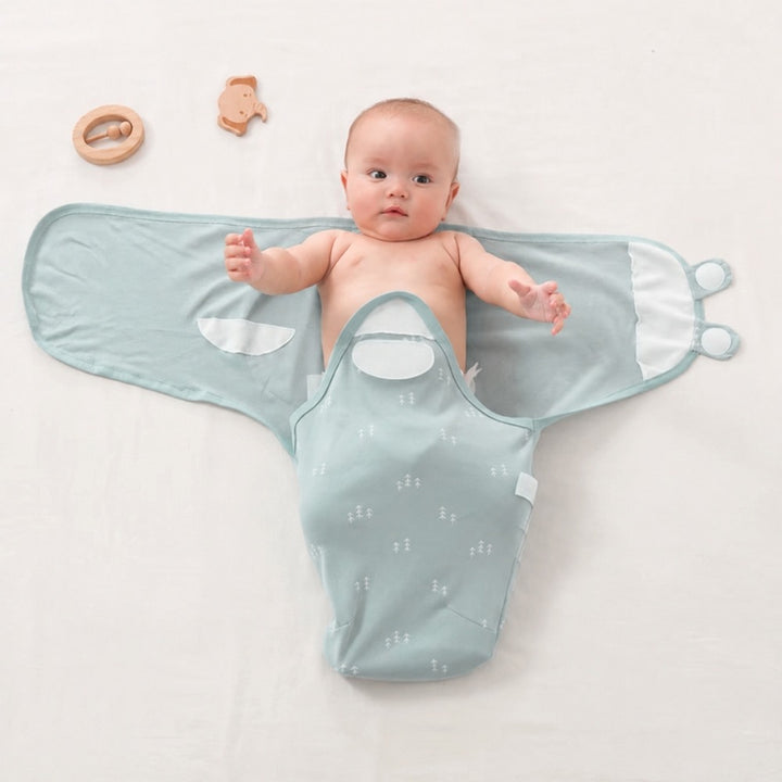 Baby lying in an open mint wrap with legs in pouch