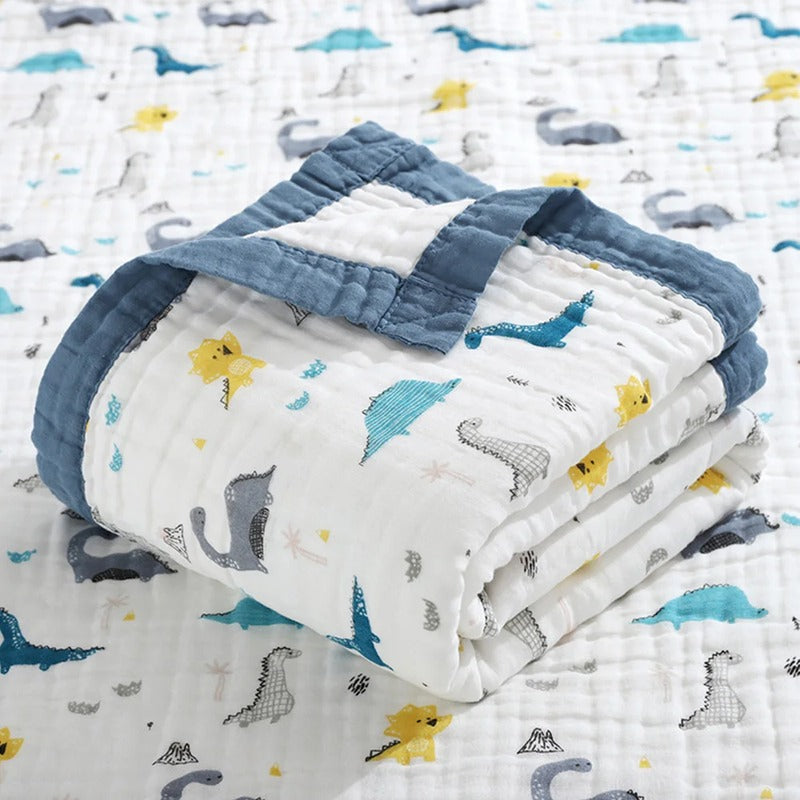 Dinosaur print blanket folded, showing blue bound edging