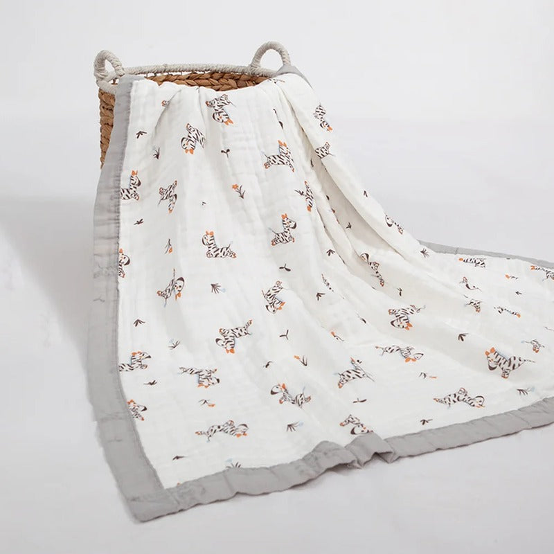 Zebra print baby wrap draped over a woven basket