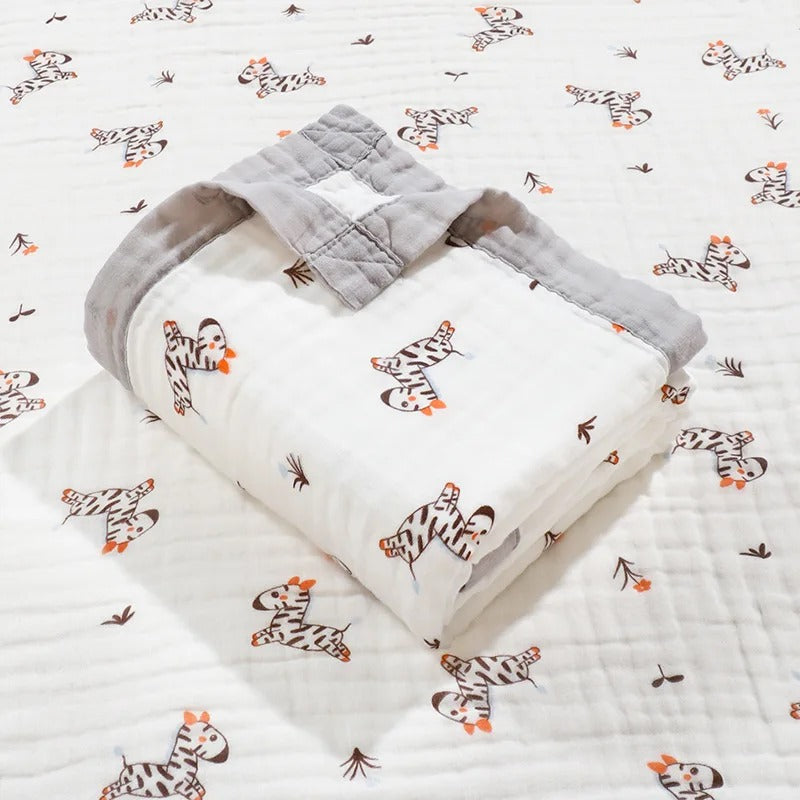 Zebra print baby wrap folded on matching gauze blanket